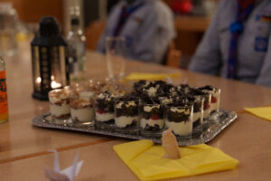 Tablett mit Dessert in Gläsern auf einem Esstisch. 